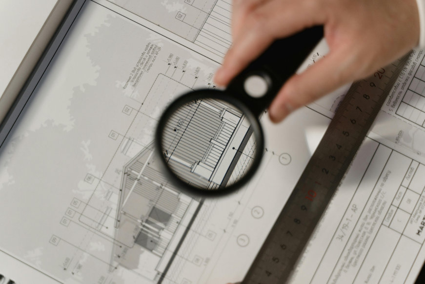 maginfying glass over plans of a building